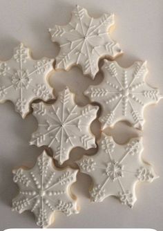 snowflake cookies with white frosting on them are arranged in the shape of stars