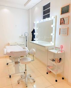 a room with a chair, mirror and lights on the wall behind it is a white tiled floor