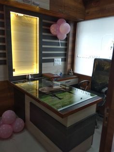 a desk with balloons and a laptop on it in a room that has been decorated for a party