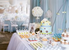 a table topped with lots of cakes and cupcakes