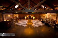 an indoor venue with rows of chairs and wine barrels