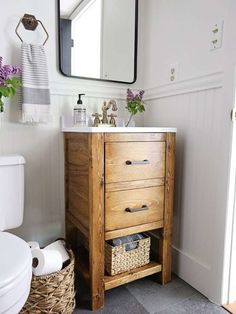 a bathroom with a sink, mirror and toilet paper roll holder in the cabinet next to it