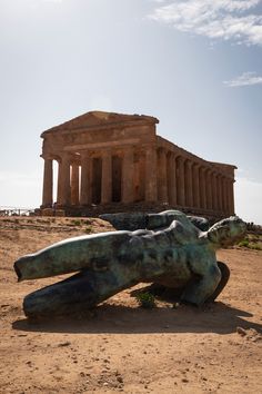 a sculpture in front of the parthenion with an ancient building in the background