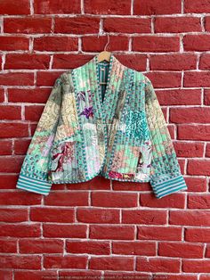 a colorful jacket hanging on a brick wall