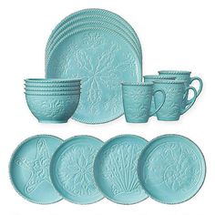 a set of blue dishes and cups on a white background with an ornate design in the center