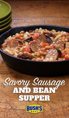 a pan filled with sausage and beans on top of a wooden table