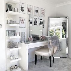 a white desk and chair in a small room with pictures on the wall above it