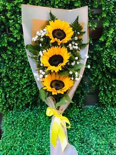 a bouquet of sunflowers in front of a green wall