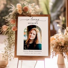 a memorial sign with an image of a woman on it and flowers in vases