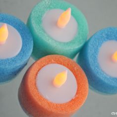 four colorful candles sitting on top of each other