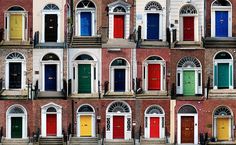 many doors are painted different colors in front of each other on the same building,