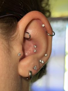 a close up of a person with piercings on their ears and behind the ear