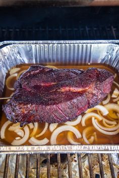 a piece of steak sitting on top of some onions in a pan next to an oven