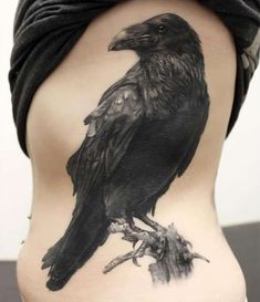 a black bird on the back of a woman's lower body, with leaves around it