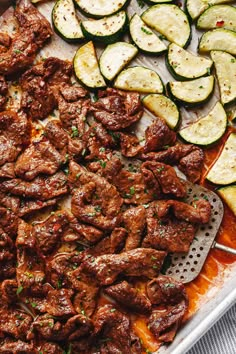 an assortment of meats and vegetables on a sheet pan with grater next to them