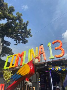 a large colorful bird statue sitting in front of a building with the word miami on it