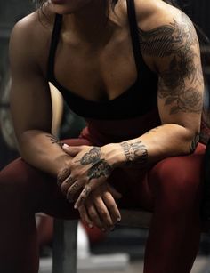 a woman with tattoos sitting on a bench