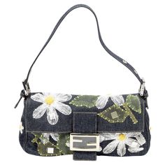 The Fendi Limited Edition Floral Embroidered Baguette in blue denim is a stunning accessory. Featuring intricate floral embroidery and silver hardware, this bag stands out effortlessly. The zipper closure ensures your essentials are secure, while the luxurious satin interior adds a touch of elegance. Inside, you'll find one zippered pocket, perfect for keeping your items organized. Ideal for adding a unique flair to any outfit. SPECIFICS Length: 10.2 inches Width: 5.9 inches Height: 13.8 inches Strap Drop: 7 inches (adjustable) Authenticity Code: 2731-26424-008 Comes With: Dust bag CONDITION Overall Condition: Excellent Exterior/Interior: Minor bend to strap, otherwise no significant signs of wear Digital Closet, Unique Purses, Fashion Sites, Bag Stand, Fendi Baguette, Baguette Bag, Embroidered Bag, Silver Hardware, Fashion Handbags