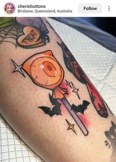 a person with a tattoo on their leg has an orange and black design on it