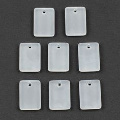 six white plastic tags on a black surface