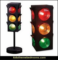 two traffic lights sitting next to each other on top of a black stand with red, green and yellow lights