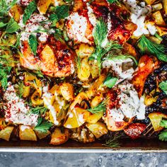 a pan filled with chicken and vegetables covered in ranch dressing, garnished with fresh herbs