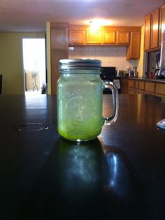 a mason jar filled with green liquid sitting on top of a counter