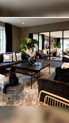 a living room filled with lots of black furniture