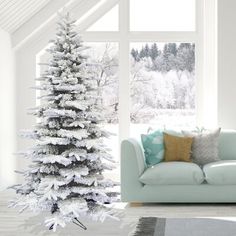 a living room with a white christmas tree next to a couch in front of a window