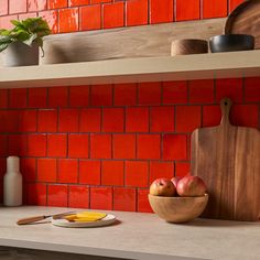 a bowl of fruit sitting on top of a counter next to a cutting board