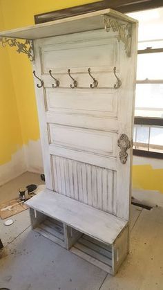 an old white door with a bench underneath it in a room that is being renovated