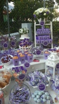 a table filled with lots of purple and white treats