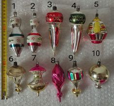 a group of christmas ornaments sitting on top of a white table next to a ruler