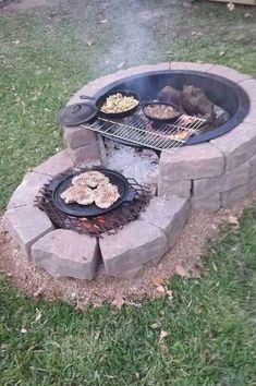 an outdoor fire pit with grills and food cooking on it