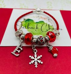 Jump into Christmas with this Pandora inspired charm bracelet with Christmas charms, Red and Silver European beads and personalised Letter on a red leather cord with barrel closure. A fabulous gift for a loved one this holiday season, the perfect present for your daughter,Grandaughter, Mum or sister, cousin or friend. This bracelet measures 7 inches (suits 6 inches and under wrist size with charms) and has a barrel lock closure. Your bracelet will be enclosed in a gold organza bag and sent to you gift wrapped in a Santa keepsake tin (pictured) for safekeeping. Costume jewelry designed in Victoria. BRACELET CARE Keep out of water Clean with a dry cloth and avoid hand creams and perfumes where possible. Store in a dry cool place. Gold Organza, Leather Charm Bracelets, Red Charm, Bracelet Christmas, Girls Red, Christmas Bracelet, Pandora Style, Bracelet Leather, Christmas Charms