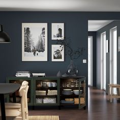 a dining room with blue walls and pictures on the wall, along with wooden flooring