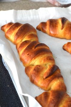 some croissants are laying on a piece of wax paper