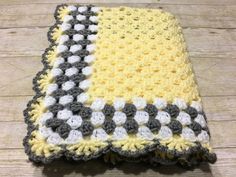 a crocheted blanket is laying on the floor