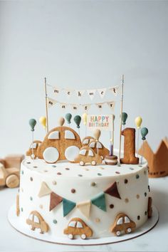 a birthday cake decorated with cars and bunting