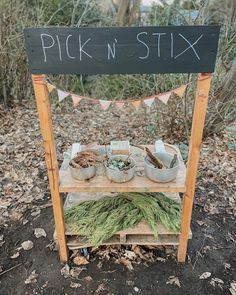 a sign that says pick n'sitx on top of a table with plants