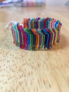 a colorful bracelet sitting on top of a wooden table