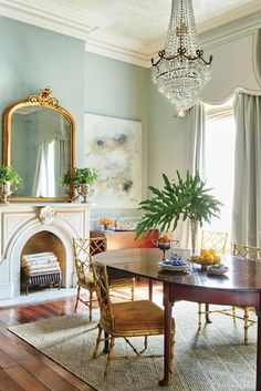 a dining room table with chairs and a mirror on the wall next to a fireplace