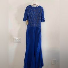 a blue dress hanging on a white wall