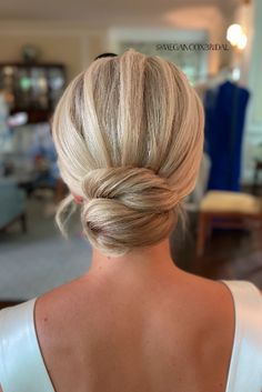 a woman with blonde hair is wearing a white dress and has her back to the camera