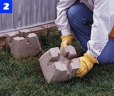 a man kneeling down next to cement blocks