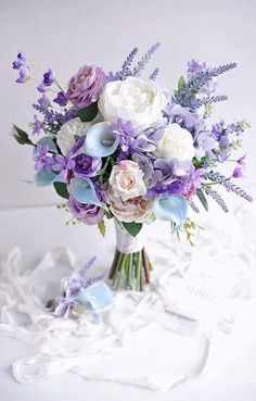 a bouquet of purple and white flowers in a vase