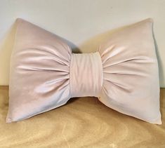 a pink pillow with a large bow on it