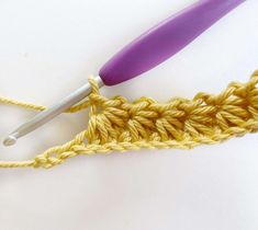 the crochet hook is being used to hold the yarn