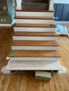 a set of stairs being installed on top of a hard wood floor in a house