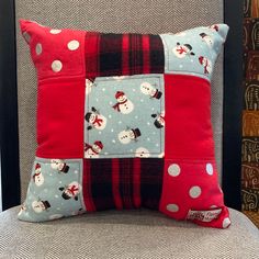 a red and blue patchwork pillow sitting on top of a chair